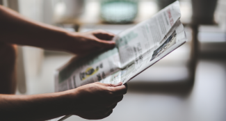 Mann hält Zeitung in der Hand
