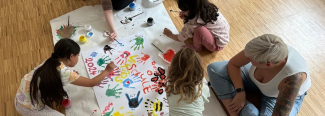 Kinder gestalten auf dem Boden ein Plakat